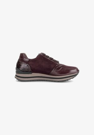 Zapatilla deportiva morada oscura con texturas de ante y cuero, talón estampado, cordones en la parte delantera y suela gruesa con rayas grises y negras.