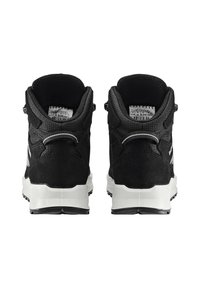 Schwarze Sportschuhe mit einem strukturierten Obermaterial aus Wildleder und Mesh. Weiße Gummisohle, gepolsterte Manschette und Zugschlaufe hinten. Reflektierende Akzente an den Seiten.