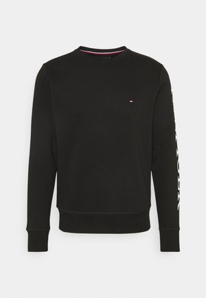 Felpa nera realizzata in misto cotone, con maniche lunghe, collo a giro e dettaglio logo. Polsini e orlo a costine per una texture definita.