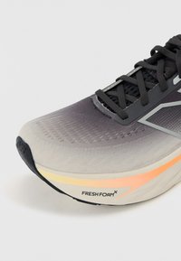 Lehká běžecká bota s gradientovým šedým svrškem, černými tkaničkami a detaily "FRESH FOAM" na podrážce, která má texturované vzory.