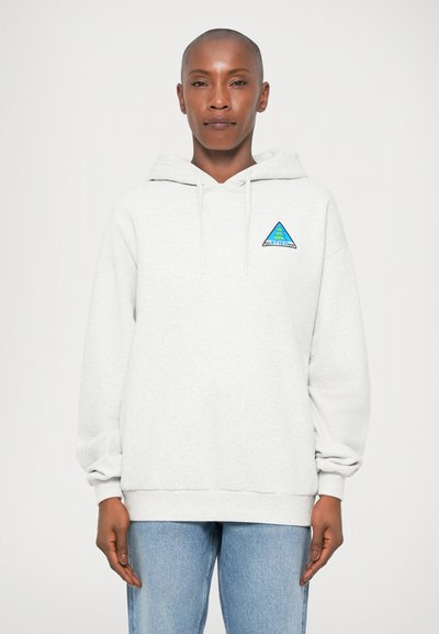 Sweatshirt à capuche gris clair avec un logo brodé triangulaire bleu et vert sur la poitrine. Il présente une coupe décontractée et des poignets côtelés.