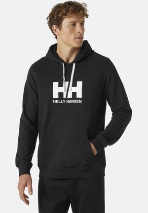 Schwarzer Hoodie aus einem Baumwollmischgewebe mit einem großen weißen "HH"-Logo und "HELly HANSEN"-Schriftzug. Er verfügt über eine Fronttasche und eine verstellbare Kapuze mit Kordelzug.