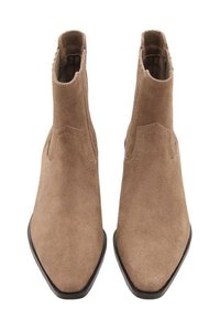 Botas de ante marrón hasta el tobillo con punta afilada, paneles elásticos en los lados y suela plana. La textura es suave y lisa, exhibiendo un diseño minimalista.