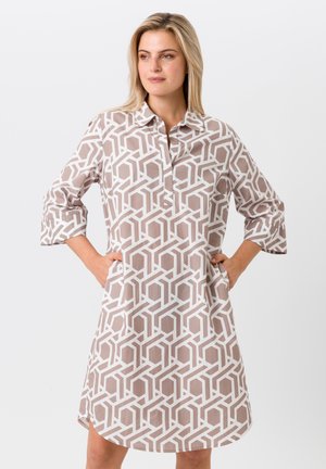 Leichtes Hemdkleid in Beige mit einem geometrischen weißen Muster. Merkmale sind ein Kragen, eine knöpfbare Vorderseite und 3/4-Rollärmel.