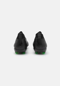 Black football boots with a sleek design, textured surface, and green studs. Features a snug fit collar for ankle support.