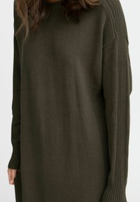 Maglione over-size verde oliva con dettagli a coste sulle maniche e scollatura a girocollo classica. Tessuto morbido, vestibilità comoda.