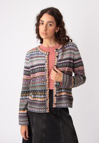 Cardigan lavorato a maglia con motivi geometrici multicolori, tonalità di grigio e rosa, scollo rotondo e apertura con bottoni. Texture morbida e maniche lunghe.