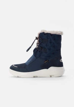 Marineblaue wasserdichte Knöchelboots mit Kunstfellbesatz, strukturiertem Obermaterial, elastischem Einsatz und weißer Gummisohle, ausgestattet mit einem Herausziehband-Verschluss.