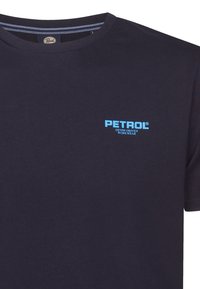 Granatowa bawełniana koszulka z okrągłym dekoltem i nadrukowanym logo w jasnoniebieskim kolorze. Logo brzmi "PETROL DENIM DRIVEN WORKWEAR."