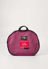 Pink mesh duffel bag with a black trim and top handle. Features a red label indicating size and material. Zipper closure. 77 liters capacity.