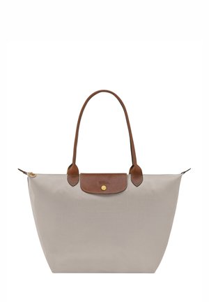 Beige tote bag made of nylon with brown leather accents and handles, featuring a gold button clasp and a structured shape.