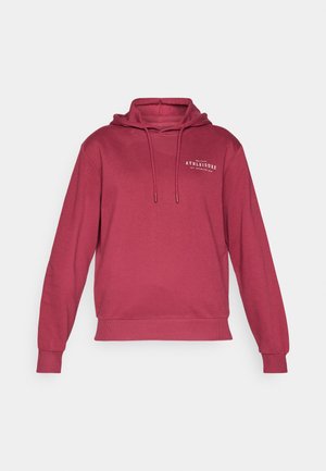 Bordeaux hettegenser med snorer og en frontlomme. Har en liten hvit grafisk tekst "ATHLEISURE" på brystområdet. Mykt stoff.