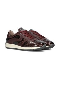 Burgunderfarbene Sportschuhe aus glänzendem Leder imKrokodilmuster, mit dicken Schnürsenkeln und einer weißen Gummisohle. Runde Zehenpartie, dezentes Branding auf der Zunge.