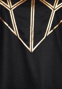 Černá tkanina má geometrický design ve zlatém fólii připomínající diamantový tvar, který zvýrazňuje ostré úhly a čisté linie.