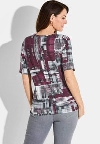 T-shirt met korte mouwen van zachte stof, met een kleurrijk abstract patroon in bordeaux, grijs en wit; ronde halslijn en licht gebogen zoom.