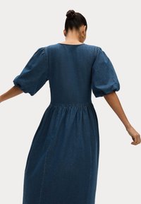 Denim jurk met een getailleerd lijfje, pofmouwen en een gathered taille, in een donkerblauwe tint met een gladde textuur.