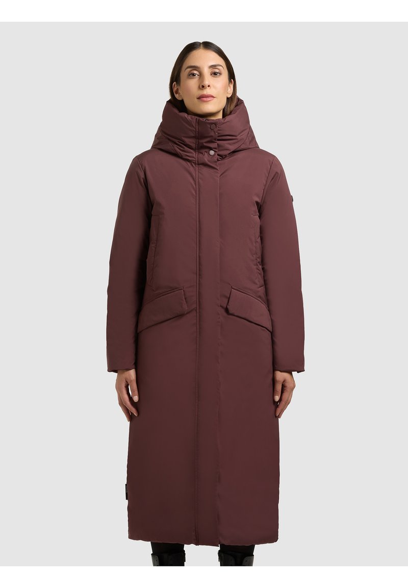 Hosszú bordó pufi kabát magas gallérral, elöl gombos rögzítéssel, két nagy zsebbel és egyenes szabással. Simított textúrájú és szigetelt.