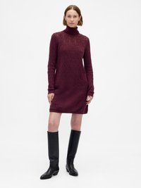 Rochie tricotată burgundy cu guler înalt  și mâneci lungi, având un model texturat în formă de diamant. Asortată cu cizme negre până la genunchi.