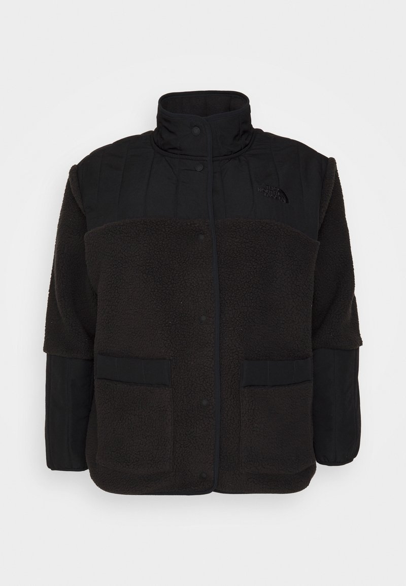 Svart jacka med en fleece-kropp och en vadderad överdel. Ståkrage, tryckknappar och två framfickor. Mjuk textur.