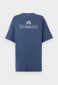 Μπλε κοντομάνικο T-shirt με λευκό κείμενο "NIKE CLUB SINCE 1972" και έμβλημα στο κέντρο του στήθους.