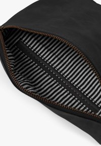 Black leather pouch with a bronze zipper, opened to reveal a black and white striped fabric interior lining and an internal flat pocket.
