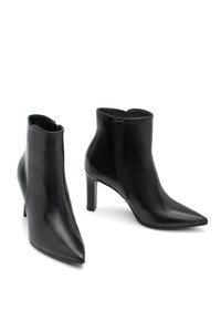 Botas de cuero negras hasta el tobillo con punta afilada, tacón alto y delgado, y detalle de cremallera lateral. Textura suave y diseño minimalista.