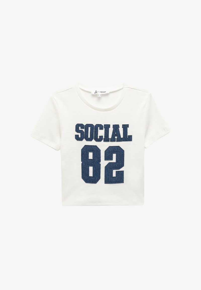 Valkoinen lyhythihainen t-paita, jonka etupuolella on tummansiniset "SOCIAL" ja "82" -painatukset. Valmistettu pehmeästä puuvillasta, jossa on ribbitekstuuri.