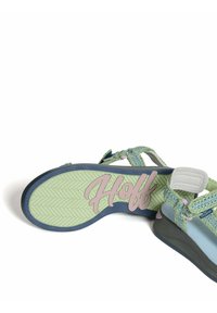 Sandalias con tiras en verde y azul, con parte superior tejida, suela acolchada y logo "Hoff" en la parte inferior texturizada.