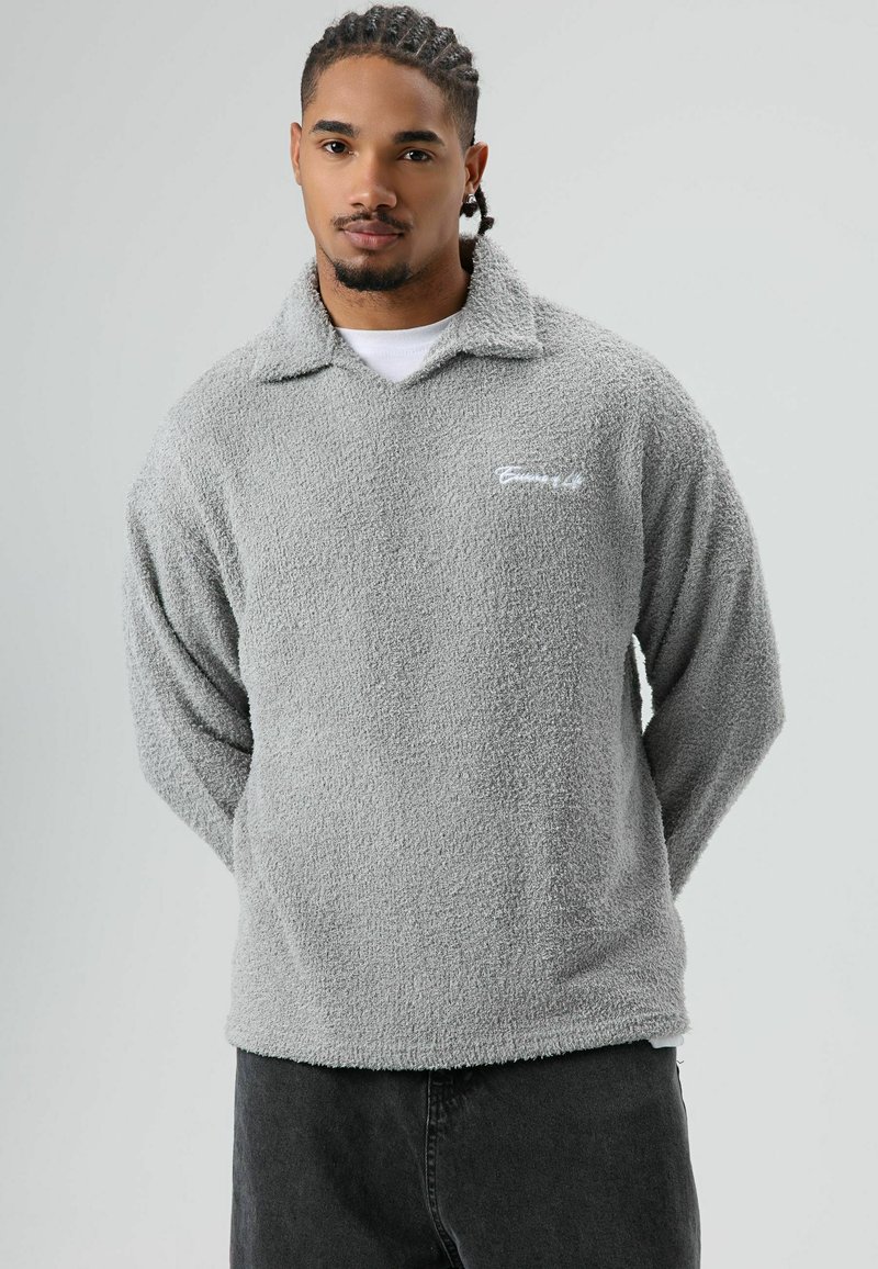 Grijze fleece pullover met een kraag, lange mouwen en geborduurd logo. Zachte textuur met een losse pasvorm en zoom.