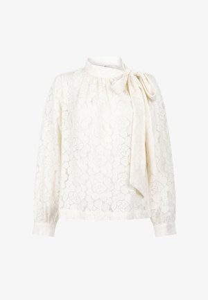 Witte kantblouse met lange mouwen, bloemmotief, hoge halslijn en een strik aan de rechter schouder.