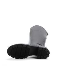 Czarne gumowe botki sięgające do kolan o gładkiej powierzchni, teksturowanym dnie i grubym wzorze bieżnika zapewniającym przyczepność. Posiadają zaokrąglony czubek.