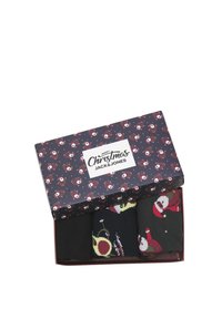 Doos met drie paar sokken, voornamelijk zwart, met feestelijke patronen van de kerstman en versieringen, in een feestelijk bedrukte doos.