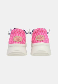 Zapatillas de tela rosa con suelas blancas, que presentan un parche con el logo "HEY DUDE" y detalles ajustables en púrpura y gris.