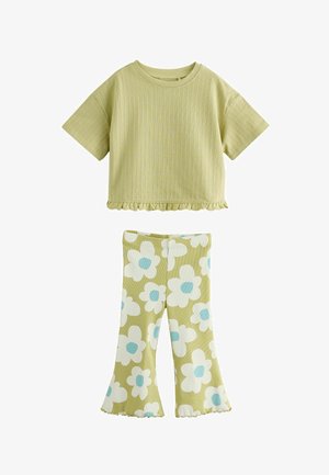 Svetlozelený rebrovaný krátky top s volánovým lemom a zodpovedajúce rozšírené nohavice s veľkými bielo-modrými kvetinovými vzormi.