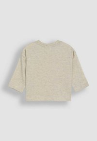 Helles beiges, kürzes T-Shirt mit langen Ärmeln, aus weichem Baumwollmixstoff gefertigt, mit rundem Ausschnitt und minimalen Nähdetails.