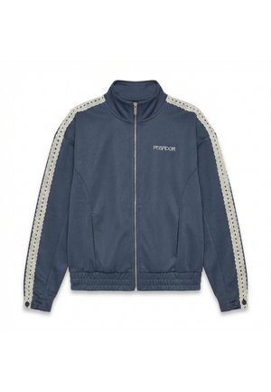 Tummansininen vetoketjullinen takki, jossa korkea kaulus, valkoiset virkatut raidat hihoissa, joustava vyötärönauha ja "PEGADOR"-logo vasemmassa rinnassa.