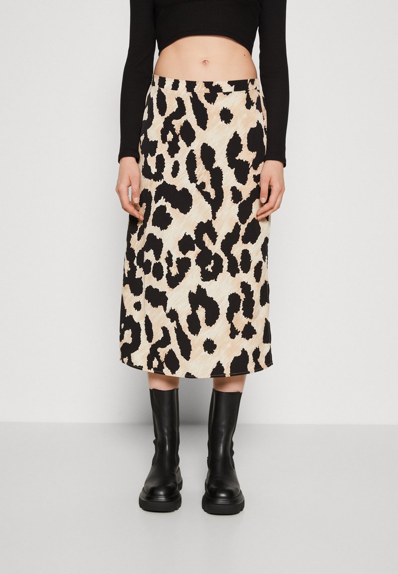 Falda midi de estampado de leopardo en beige y negro, con una textura suave, cinturilla alta y un par de botas negras hasta el tobillo.