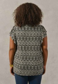 Svart- och vitt mönstrad topp med diamanterdesign, korta fladderärmar och avslappnad passform. Slät tyg med en mjuk textur.