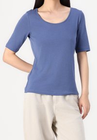 Camiseta de algodón azul de manga corta con escote redondo y un diseño ajustado. Textura suave, costuras simples y sin patrones visibles.