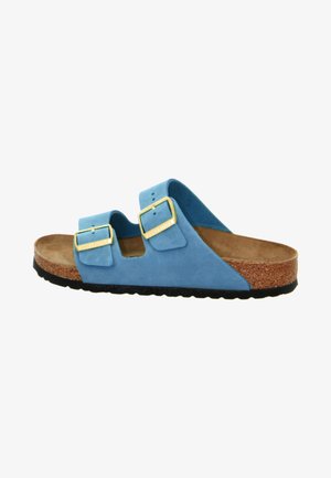 Blue suede sandal with two adjustable gold buckles, cork footbed, and textured black rubber sole. Open-toe design with curved edges.
