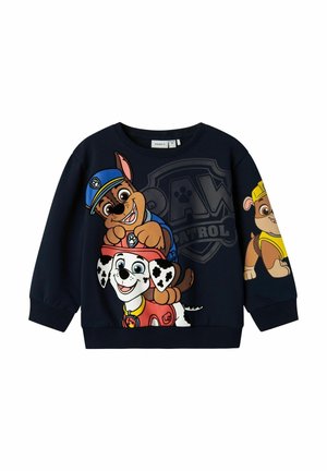 Marineblauwe sweater met grote kleurrijke Paw Patrol-personages, waarvan één een politiemuts draagt, een andere een rode helm, en een derde een gele bouwhelm.
