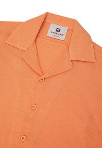 Camisa naranja de botones con cuello, con tres botones visibles y una etiqueta "Gabbiano Medium" dentro del cuello.