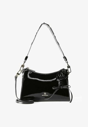 Schwarze Handtasche aus Lackleder mit geschwungener Form, floralem Akzent und verstellbarem Riemen. Verfügt über ein Logo am Boden und eine glänzende Oberfläche.