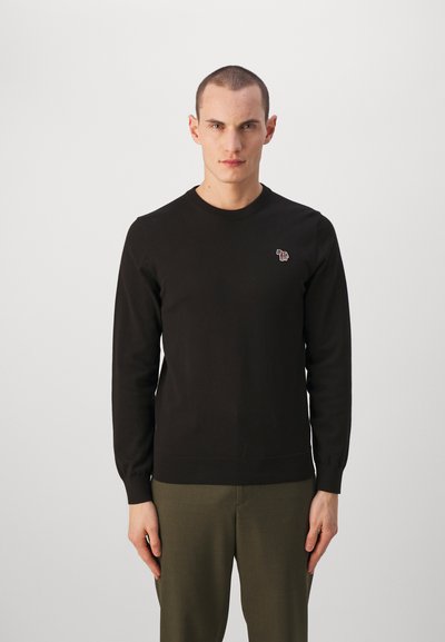 Μαύρος πουλόβερ από πλεκτό ύφασμα, με μακριά μανίκια και στρογγυλή λαιμόκοψη. Μικρό λογότυπο ελέφαντα στο αριστερό στήθος.