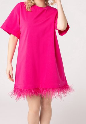 Lyserød oversized t-shirt-kjole med en blød, fjerlignende kant. Fremstillet i glat stof, den har rund halsudskæring og korte ærmer.