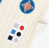 Quilted fabric featuring a beige background with embroidered blue planet and control panel designs in red, black, white, and blue.
