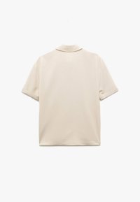 Kortärmad beige skjorta med en mjuk textur, flikkrage och uppvikta ärmar. Slät tyg med rak skärning och inga synliga mönster.