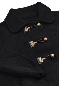 Cappotto di lana nera con ampio colletto e tre chiusure a bottone dorate con anelli in pelle nera.