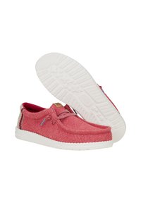 Scarpe slip-on rosse in tessuto, con tomaia testurizzata, suola in gomma bianca e lacci a contrasto. Presentano cuciture decorative sui lati e un logo.