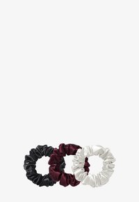 Set di tre elastici per capelli in morbido raso: nero, burgundy e bianco. Ognuno presenta un tessuto arricciato con una consistenza morbida e un design elastico.